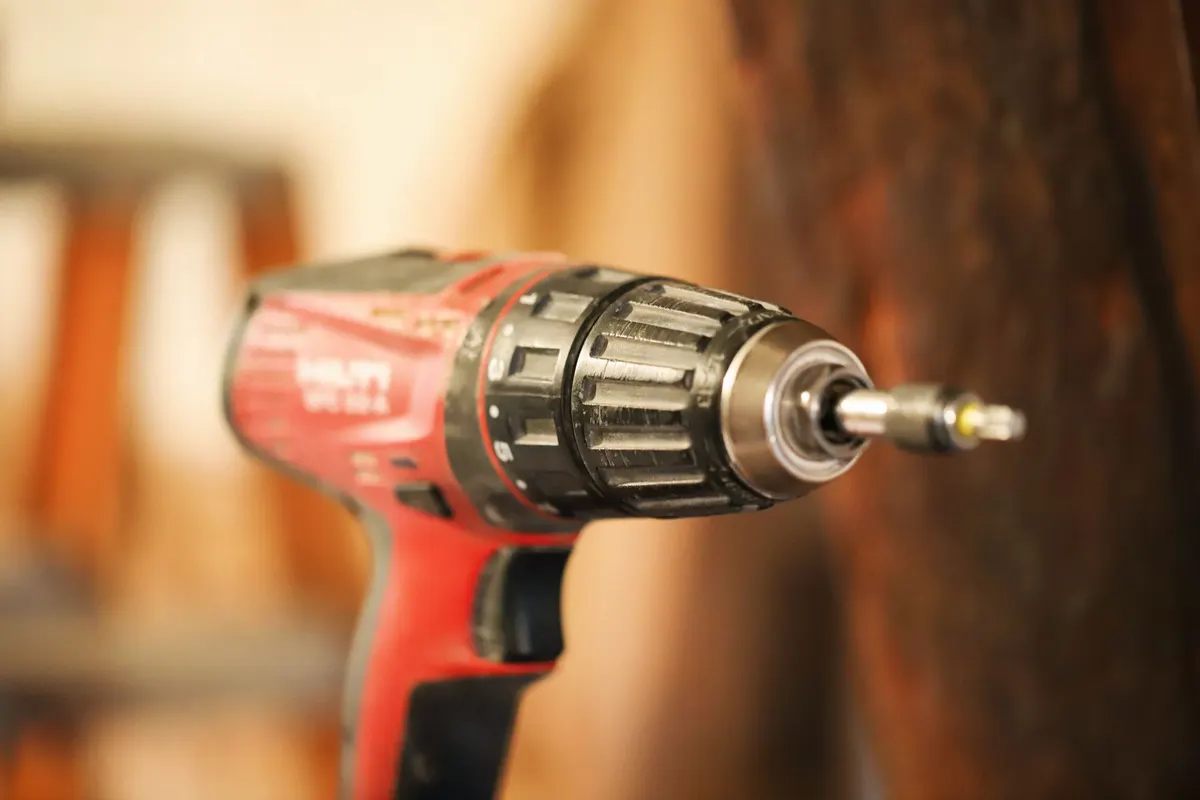 Overhead view of a cordless drill driver surrounded by drill bits and accessories on a workshop table