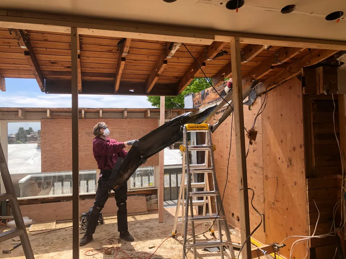 Reciprocating saw cutting through framing lumber during a home renovation demolition