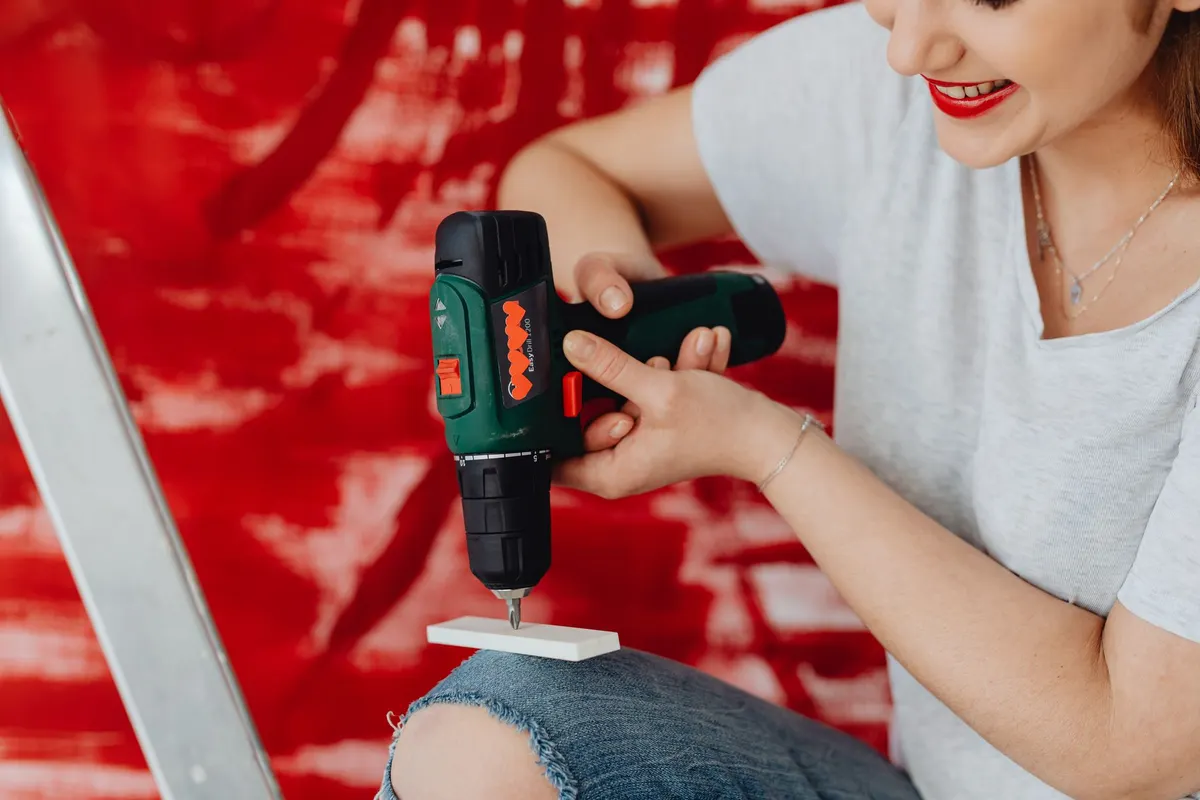 First-time DIYer using a cordless drill to assemble furniture at home